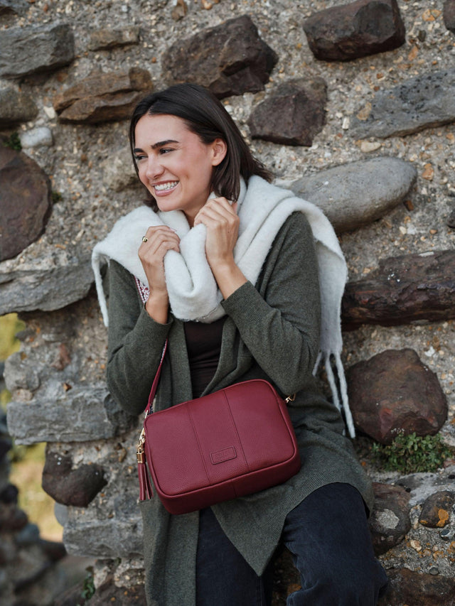 Pom Pom London City Plus crossbody bag in Burnt Rhubarb worn over a winter coat and scarf